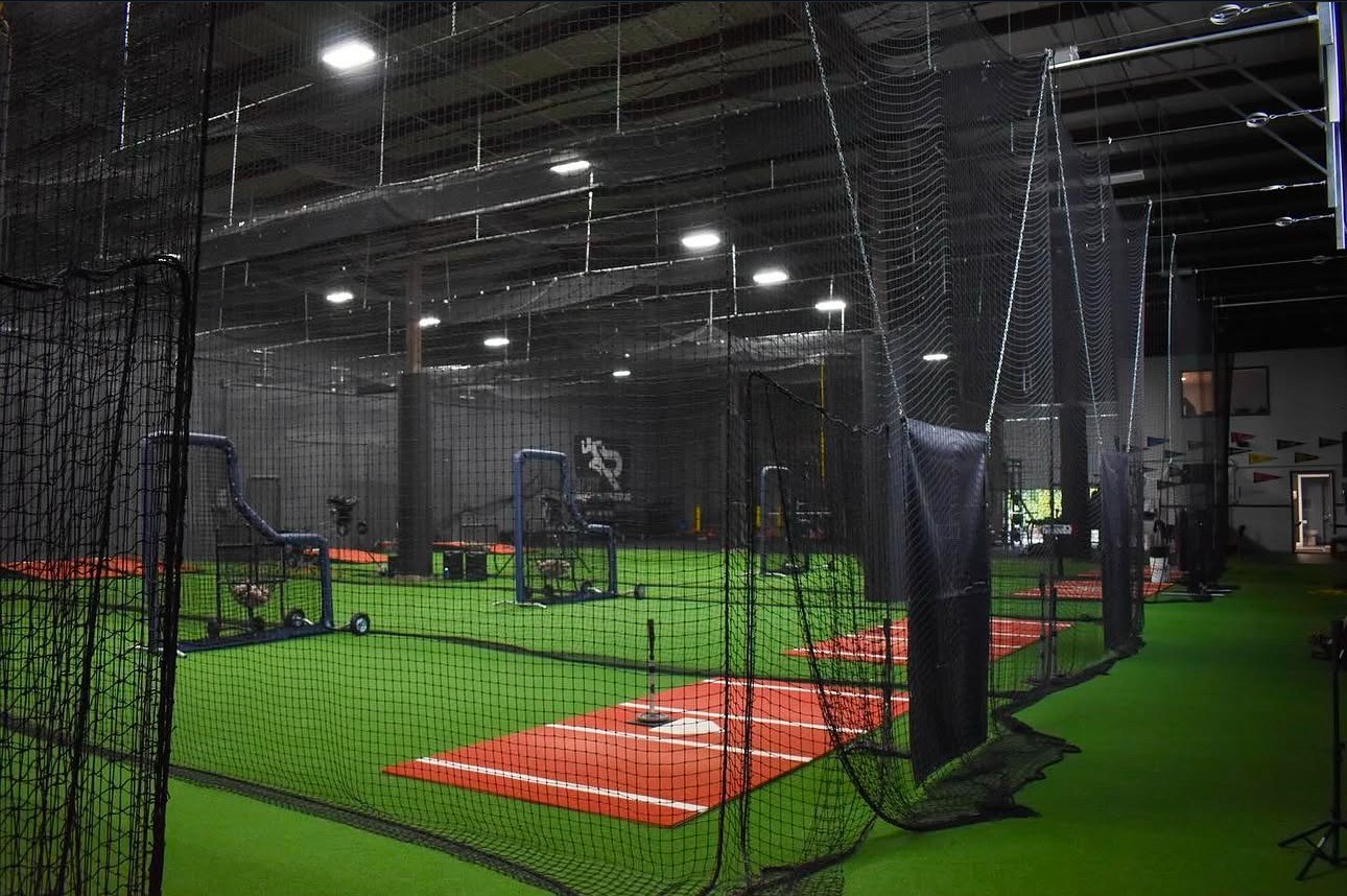 Indoor batting cages with turf lanes, pitching machines and clay mounds at Rip City Academy
